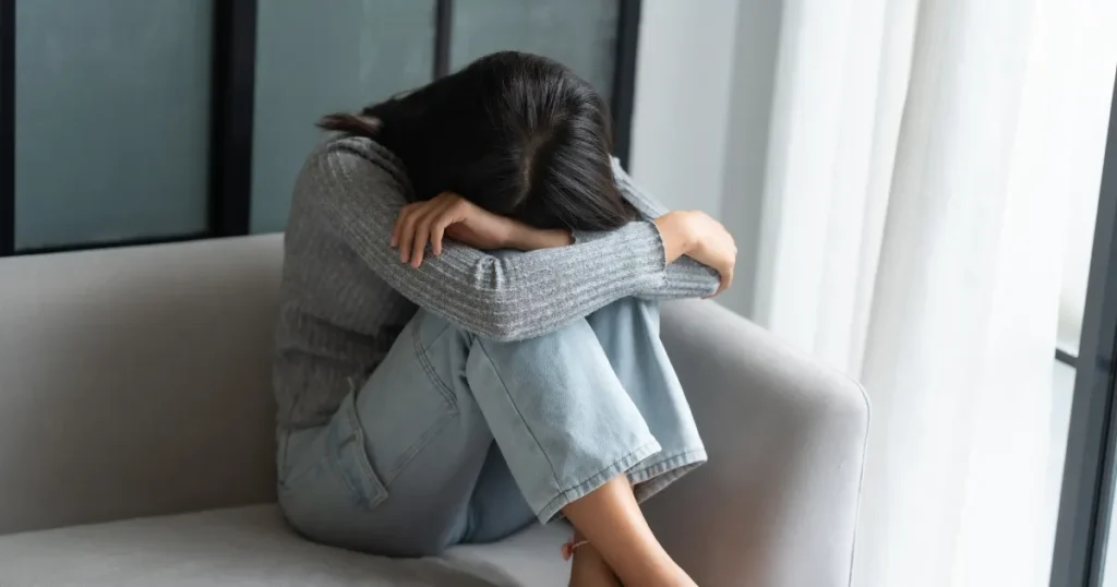 Mulher refletindo em ambiente interno ilustrando a diferença entre tristeza e depressão